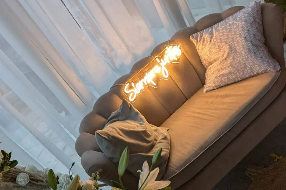 Sofá con neón y arco floral
